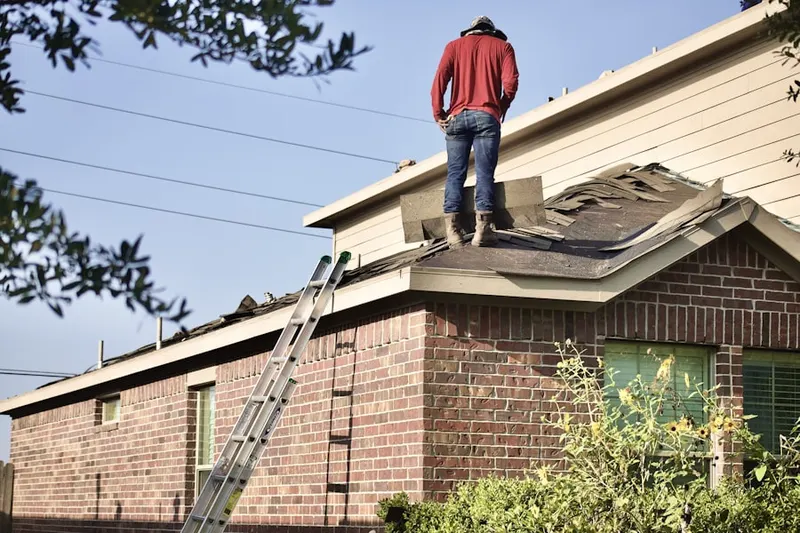 Professional roofer working on a residential roof in Midway East